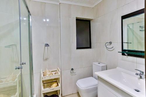 a bathroom with a shower and a toilet and a sink at La Pirogue 1 in Westbrook