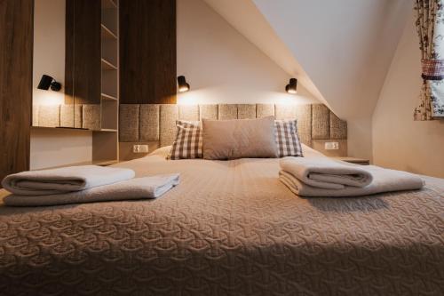a bedroom with a large bed with towels on it at Dom Wypocz Pod Litwinką Apartamenty in Białka Tatrzanska