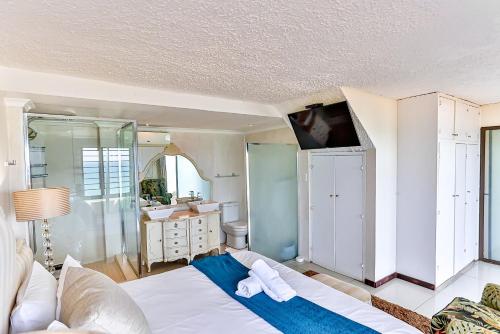 a bedroom with a large bed and a bathroom at La Pirogue 1 in Westbrook