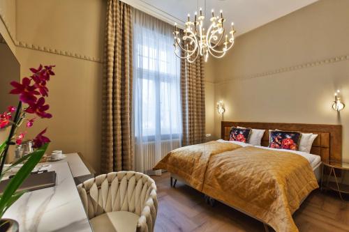 a bedroom with a bed and a chandelier at Mestský Hotel Ďumbier in Brezno