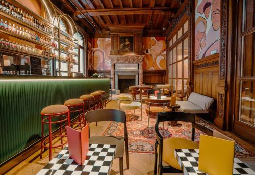 a restaurant with a green bar with chairs and tables at CENTRAL Hôtel Lille Centre in Lille
