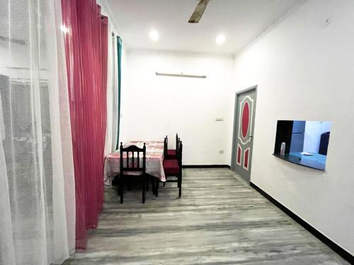 a dining room with a table and a tv on a wall at KPS homestay in Puducherry