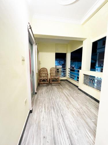 an empty room with two chairs and windows at KPS homestay in Puducherry