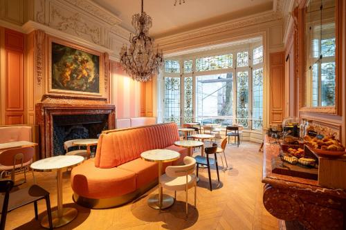 a living room with a couch and tables and a fireplace at CENTRAL Hôtel Lille Centre in Lille