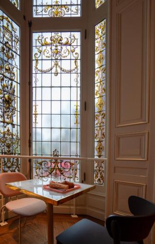 a room with a table and stained glass windows at CENTRAL Hôtel Lille Centre in Lille