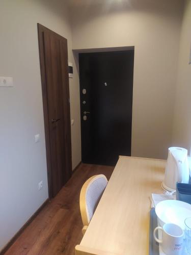 a room with a table and two chairs and a door at RVR Smart Apartments Riga with Free Parking and Self Check-in in Rīga