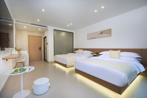 a hotel room with two beds and a table at Perfect holiday inn in Yangshuo