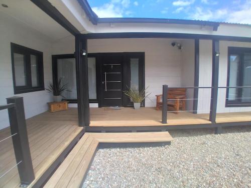a house with a deck with a glass door at Complejo Del Este Suites in San Carlos de Bariloche