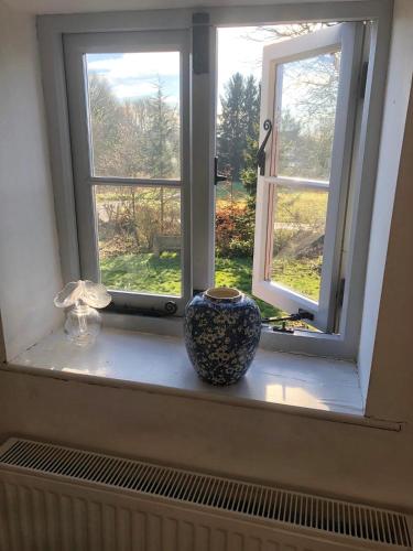 a vase sitting on a window sill in front of a window at Logaston Common Farmhouse in Woonton