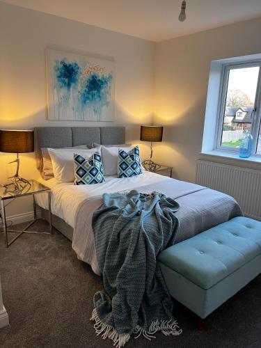 a bedroom with a large bed and a blue couch at 5BR for 9 l BIG Parking l Perfect for Contractors in Higham on the Hill
