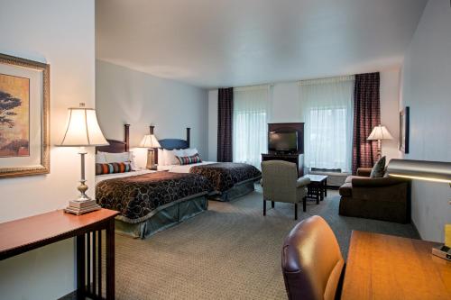 um quarto de hotel com uma cama e uma sala de estar em Staybridge Suites Rockford, an IHG Hotel em Rockford