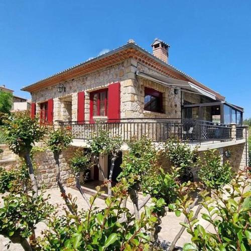 Cette maison en pierre dispose d'un balcon et de finitions rouges. dans l'établissement La Jolie Maison de Banne, 4 étoiles, piscine privée chauffée, calme, à Banne