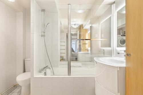 une salle de bain blanche avec une douche et un lavabo dans l'établissement Ballerine, à Paris