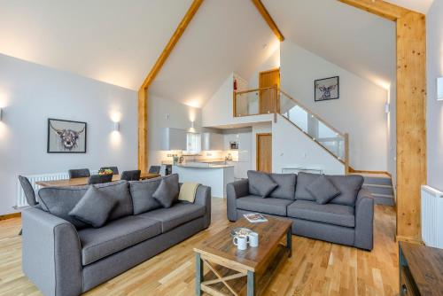 a living room with two couches and a staircase at Landal Twin Lakes in Carnforth