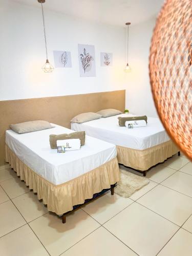 two beds in a room with a mirror at Hotel Leda Rafael in João Câmara