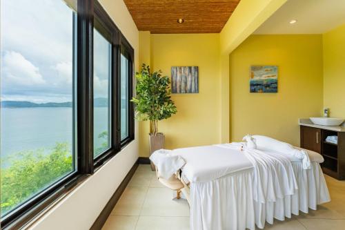 a room with a bed and a large window at 360 Splendor 405 Ocean View Condo- With Breakfast in Playa Flamingo
