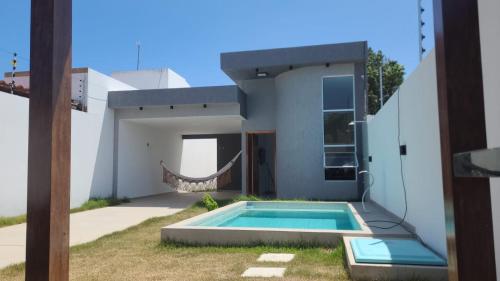 a house with a swimming pool in the backyard at Bela casa jacumã in Conde