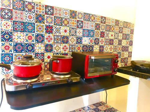 a counter with two pots and a toaster oven at Chalé Oliva Mar Doce de Abrolhos in Caravellas