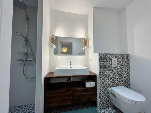 une salle de bain avec un lavabo et des toilettes dans l'établissement Villas climatisées avec piscine et SPA proche du lac, à Lacanau