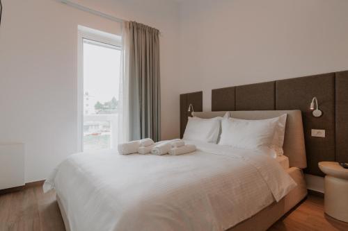 a bedroom with a large white bed with a window at Neutral Haven in Nafplio
