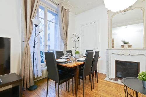 une salle à manger avec une table et des chaises et une cheminée dans l'établissement Superb Apartment Quartier Panthéon 4 Free Netflix, à Paris