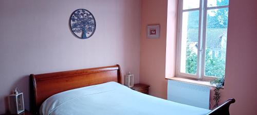 a bedroom with a bed and a window at Chambres et table d'hôte Rabillou in Saint-Moreil