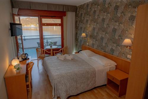 a bedroom with a bed and a table with a television at Hotel Chalet del Lago in Avigliana