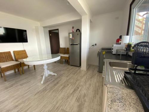 a kitchen with a table and a refrigerator at Preciosa casa frente al mar in Tongoy
