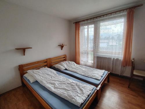 a bedroom with a bed and a window at Penzion Potočná in Žarnovica