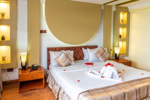 a bedroom with a large bed with red flowers on it at Hillcourt Resort and Spa in Nakuru