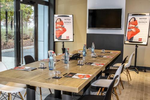 a conference room with a long table and chairs at Ibis Saint-Genis-Pouilly Genève in Saint-Genis-Pouilly