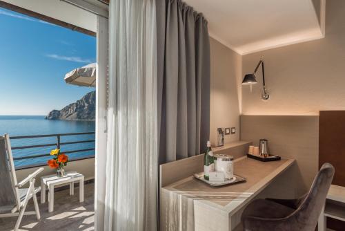 a room with a balcony with a view of the ocean at Hotel Porto Roca in Monterosso al Mare