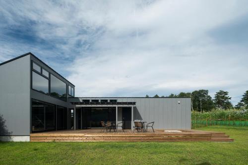 a house with a deck with two chairs on it at グランピングヴィレッジ富士河口湖 in Narusawa