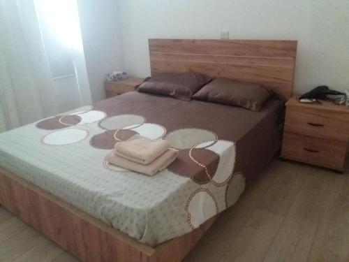 a bedroom with a large bed with a wooden headboard at alfaro57 in Nicosia