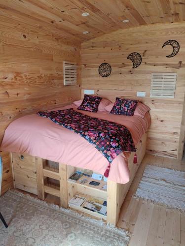 a bedroom with a bed in a log cabin at l'Eden du Sancerrois in Sens-Beaujeu