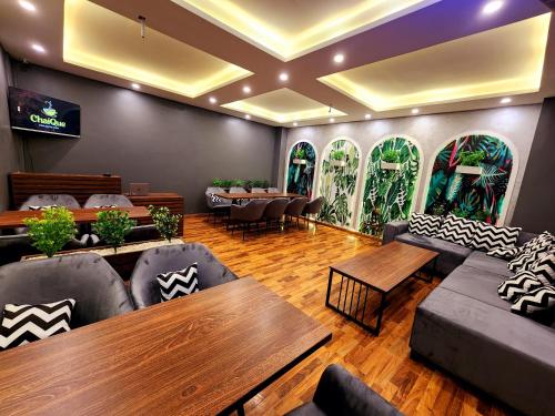 a lobby with couches and tables in a restaurant at Motorway Majesty Suites Islamabad - Near Islamabad International Airport and Motorway in Islamabad