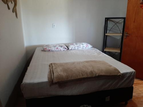 Una cama con dos almohadas encima en una habitación. en Refúgio de Paz, en Capão da Canoa