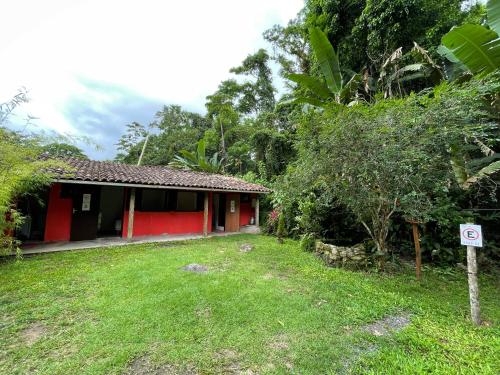 a red house with a sign in front of it at Pouso in Paraty