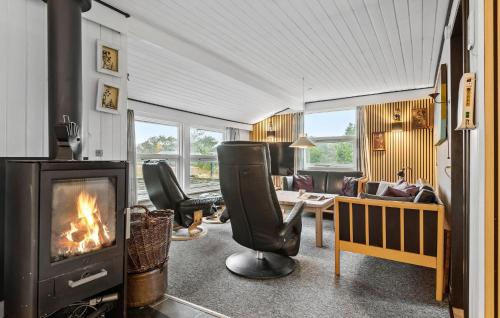 a living room with a fireplace and a table and chairs at Holiday Home Vester Kirketoft Fanø Ix in Fanø