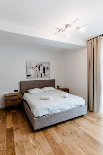 a bedroom with a large bed and a wooden floor at Evo Residence Taietura Turcului in Cluj-Napoca