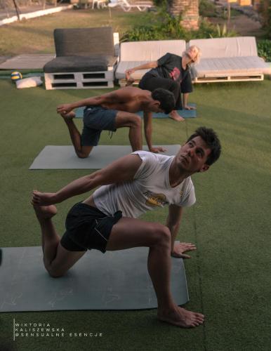 a group of people doing yoga in a yard at Adeje - TwinFin Hostel & Surf Yoga Camp in Callao Salvaje