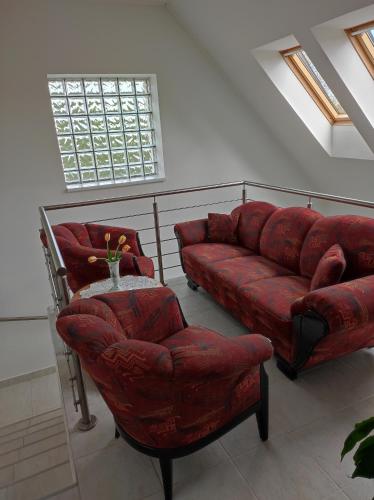 a living room with a red couch and a chair at Helga Apartman Siófok in Siófok