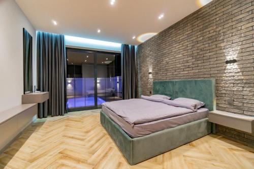 a bedroom with a brick wall and a bed at White villas in Qusar