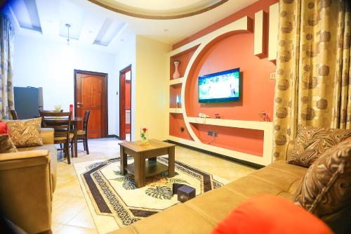 a living room with a couch and a tv at Serene Courts Kitende in Kitende