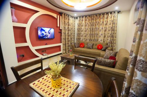 a living room with a table and a couch at Serene Courts Kitende in Kitende