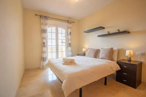 a bedroom with a large bed and a window at Espacioso apartamento en Mijas con parking privado in Sitio de Calahonda
