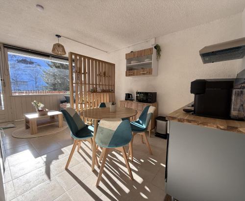 une cuisine avec une table et des chaises dans une pièce dans l'établissement L'Etoile des Sommets, à Viuz-en-Sallaz
