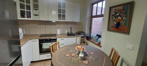 a kitchen with a table with chairs and a dining room at Senamiesčio APARTAMENTAI in Panevėžys