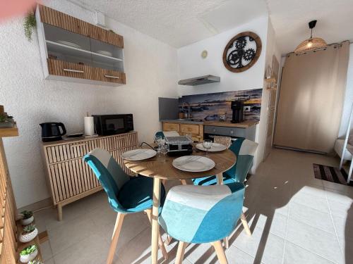 une cuisine avec une table et des chaises dans une pièce dans l'établissement L'Etoile des Sommets, à Viuz-en-Sallaz