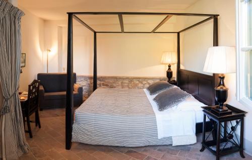 a bedroom with a canopy bed and a chair at B&B Pieve Degli Artisti in Pietrasanta